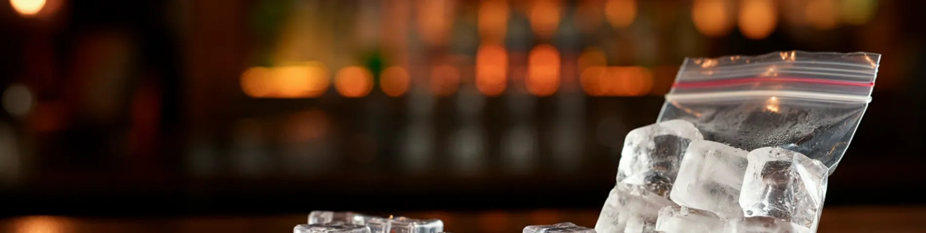 Cubitos de hielo y una bolsa de hielo sobre la barra de un bar