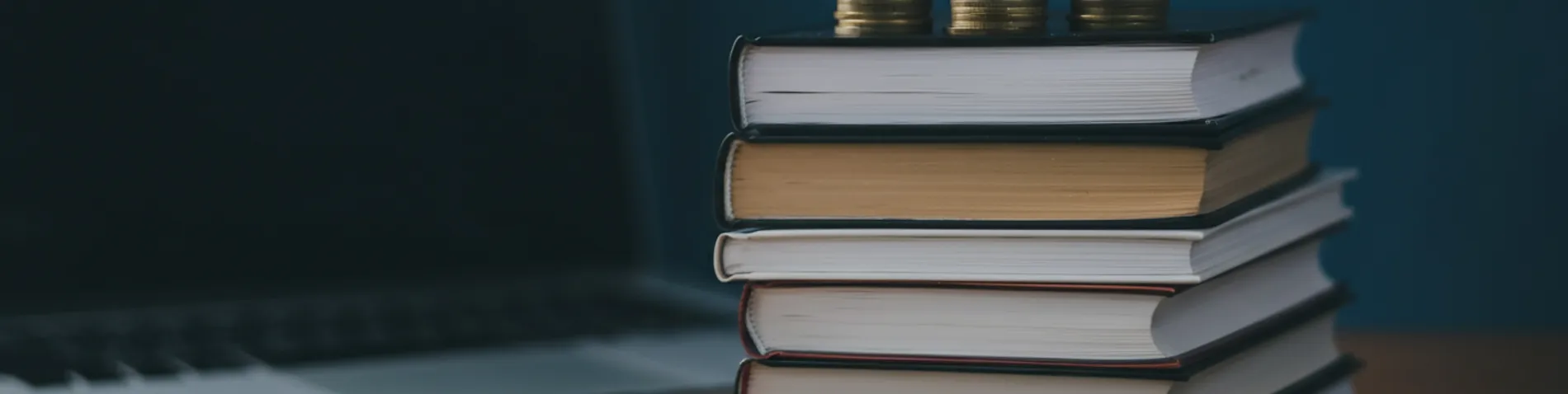 Libros apilados con monedas