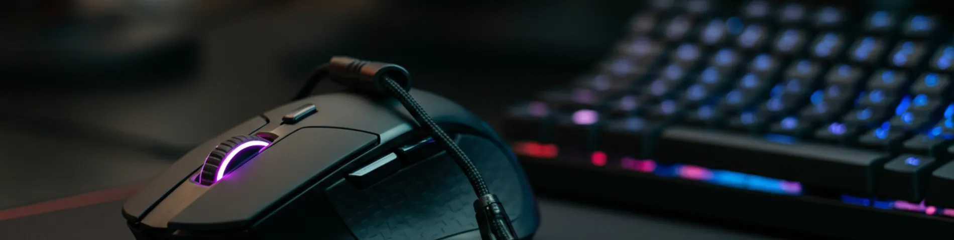 Escritorio con ratón gaming, bungee y teclado mecánico sobre un desk pad