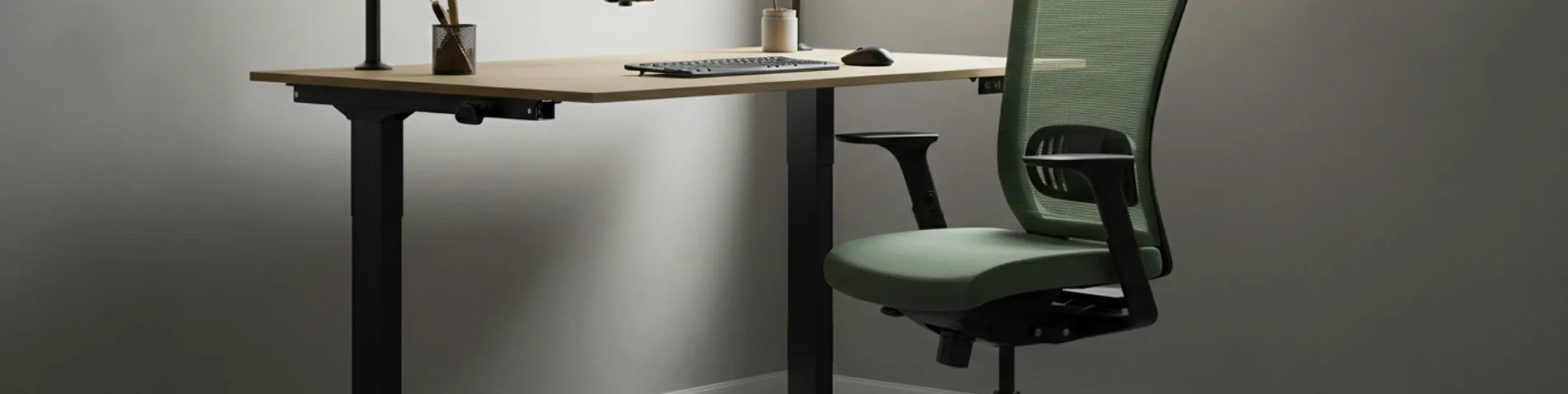 Puesto de trabajo ergonómico con silla de malla, monitor a la altura de los ojos y escritorio elevable